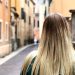 a woman with long blonde hair walking down a street